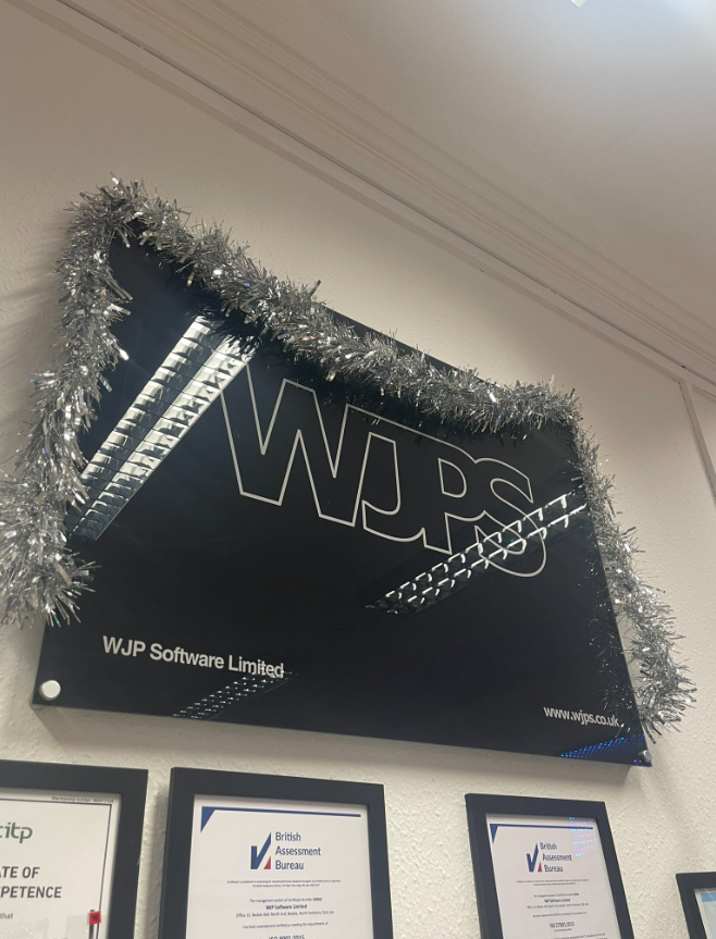 Tinsel over a sign with the WJPS logo, in the WJPS Office